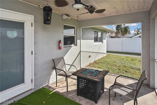 view of patio featuring ceiling fan and an outdoor fire pit