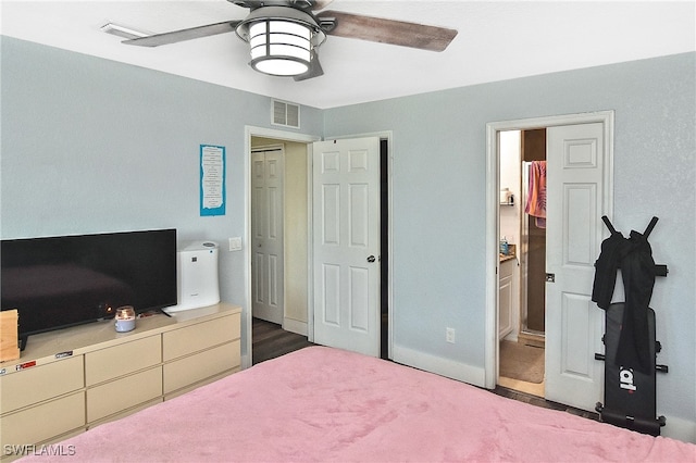 bedroom with dark hardwood / wood-style flooring, ensuite bath, and ceiling fan