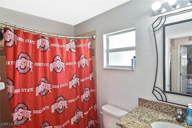 bathroom featuring vanity, toilet, and curtained shower