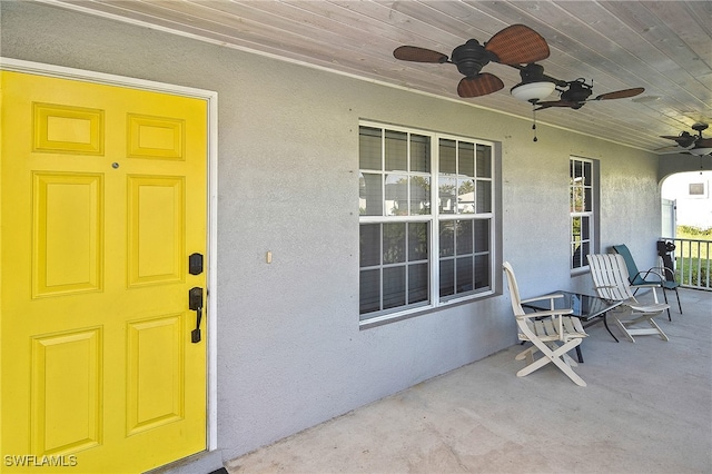 entrance to property featuring ceiling fan and a porch