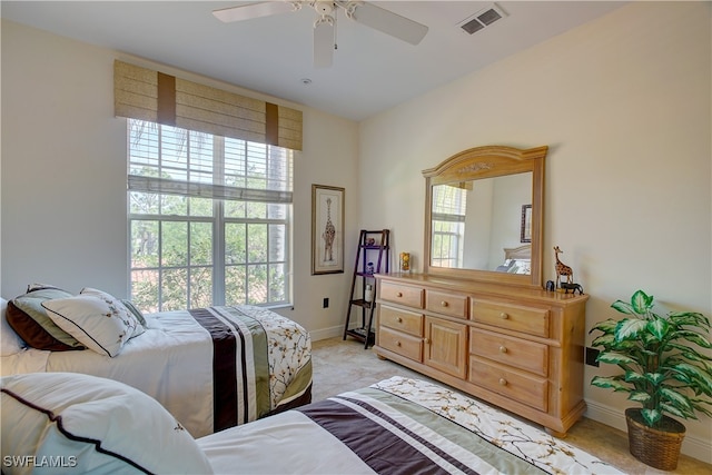 bedroom featuring multiple windows, light colored carpet, and ceiling fan