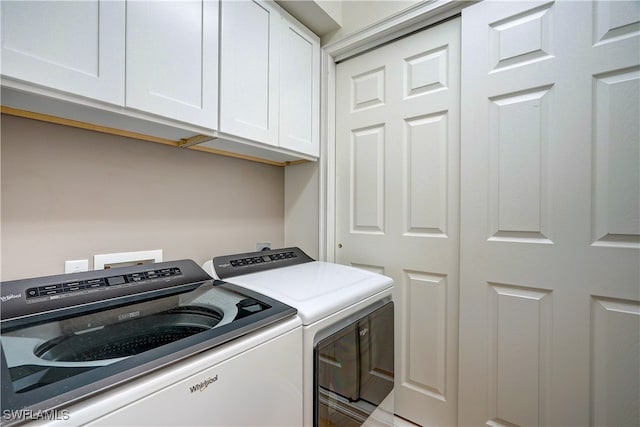 laundry area featuring separate washer and dryer and cabinets