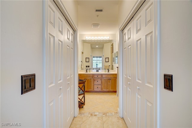 hallway with sink and light tile patterned floors