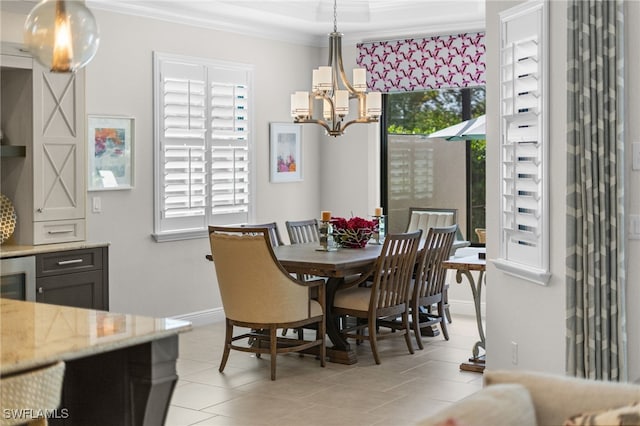 tiled dining space featuring an inviting chandelier, a wealth of natural light, and ornamental molding