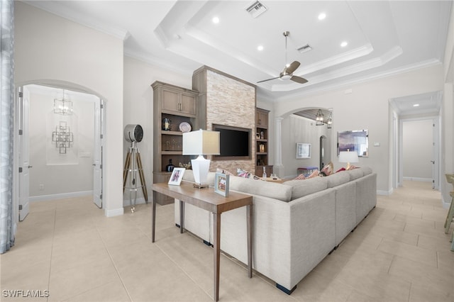 tiled living room featuring crown molding, a tray ceiling, and ceiling fan with notable chandelier