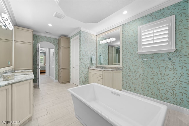 bathroom featuring crown molding, a bathing tub, and vanity