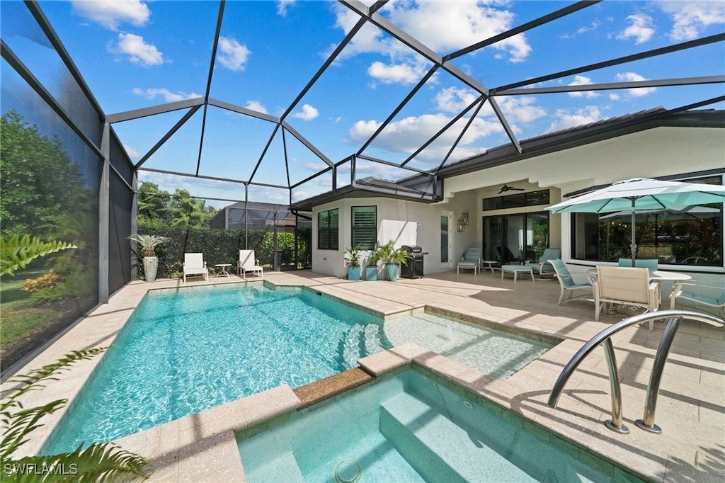 view of swimming pool featuring a lanai, a patio area, ceiling fan, and an in ground hot tub