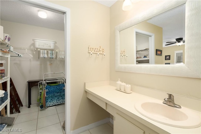 bathroom with tile patterned flooring, vanity, a textured ceiling, and ceiling fan