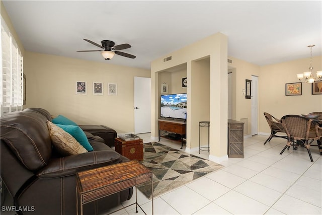 tiled living room featuring ceiling fan with notable chandelier