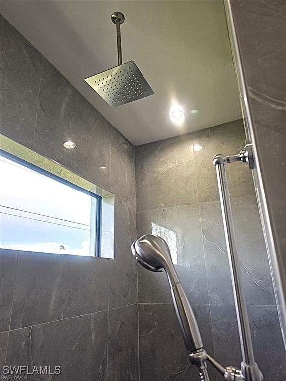 interior details featuring a tile shower