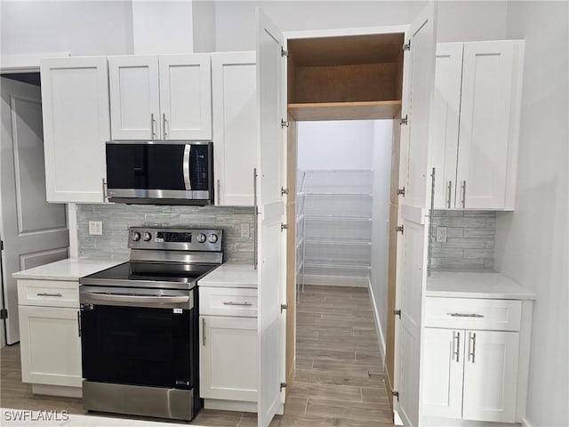 kitchen with white cabinetry, appliances with stainless steel finishes, and backsplash