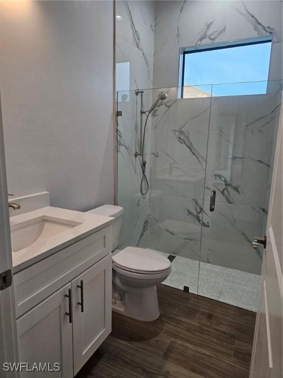 bathroom featuring vanity, toilet, and walk in shower