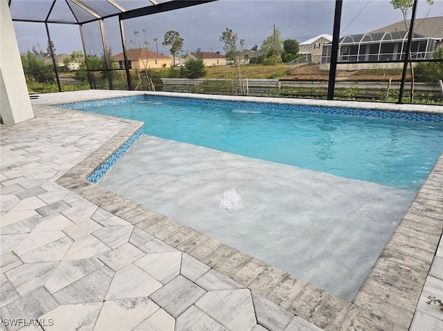 view of swimming pool featuring a lanai and a patio