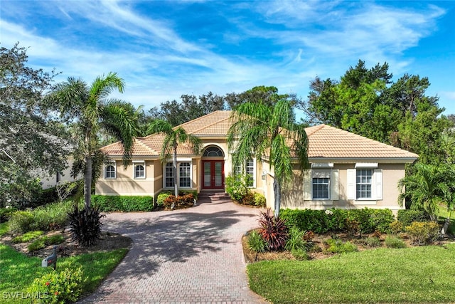 mediterranean / spanish home featuring a front yard and french doors