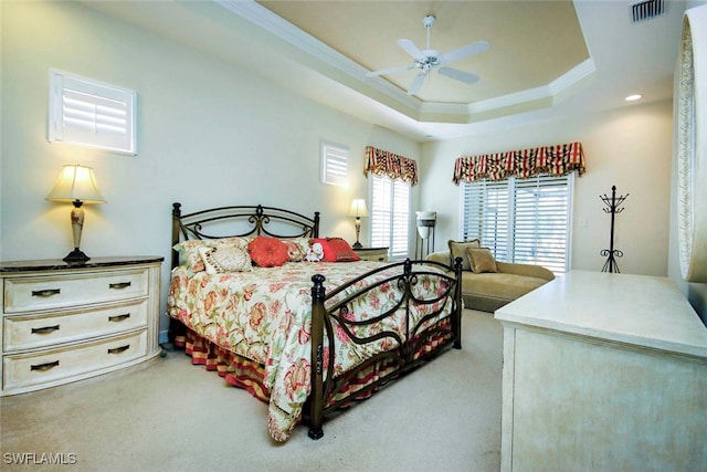 bedroom with a raised ceiling, ceiling fan, light colored carpet, and crown molding