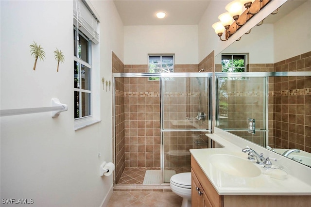 bathroom with tile patterned floors, vanity, a shower with shower door, and toilet