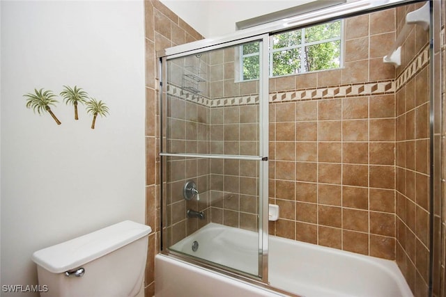 bathroom with enclosed tub / shower combo and toilet