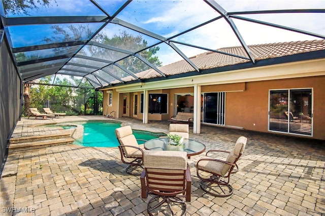 view of pool featuring glass enclosure and a patio