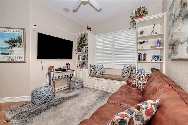 living room featuring hardwood / wood-style floors, built in features, and ceiling fan