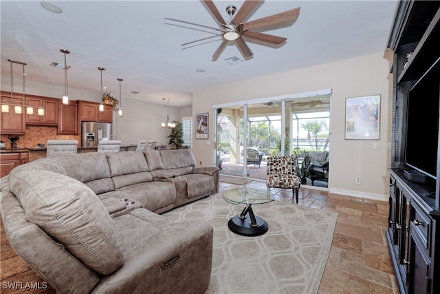 living room with ceiling fan with notable chandelier