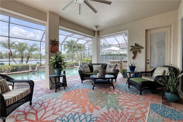 sunroom / solarium featuring a water view, ceiling fan, a healthy amount of sunlight, and a pool