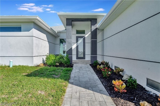 entrance to property with a lawn