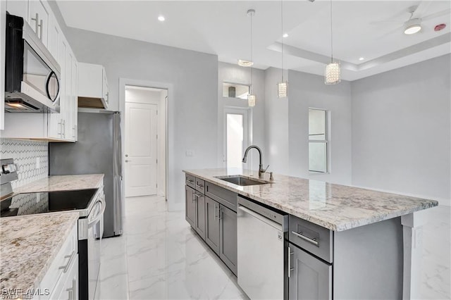 kitchen featuring gray cabinetry, sink, stainless steel appliances, pendant lighting, and white cabinets