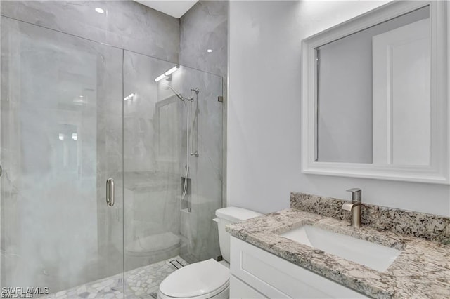 bathroom with vanity, an enclosed shower, and toilet