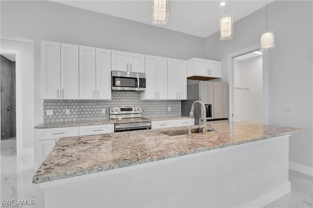 kitchen with sink, decorative light fixtures, a kitchen island with sink, white cabinets, and appliances with stainless steel finishes