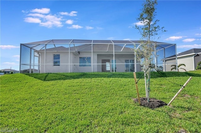 back of property featuring a yard and glass enclosure