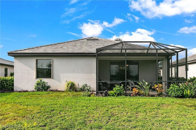 rear view of house featuring a lanai and a yard