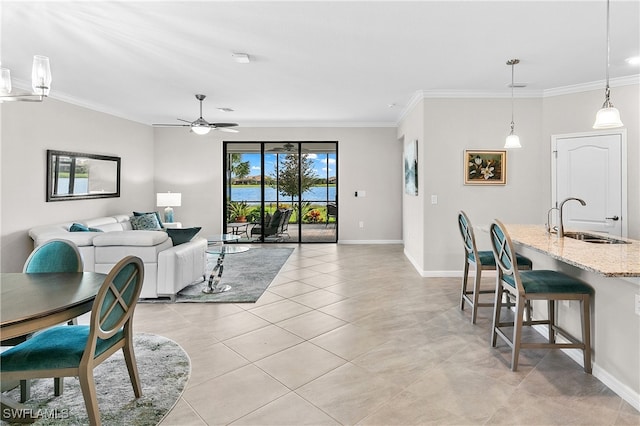 tiled living room with ceiling fan, ornamental molding, and sink