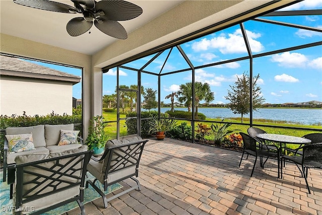 view of patio with a lanai, ceiling fan, outdoor lounge area, and a water view