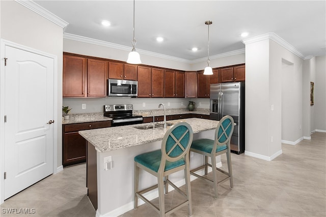 kitchen with a center island with sink, pendant lighting, light stone counters, and appliances with stainless steel finishes