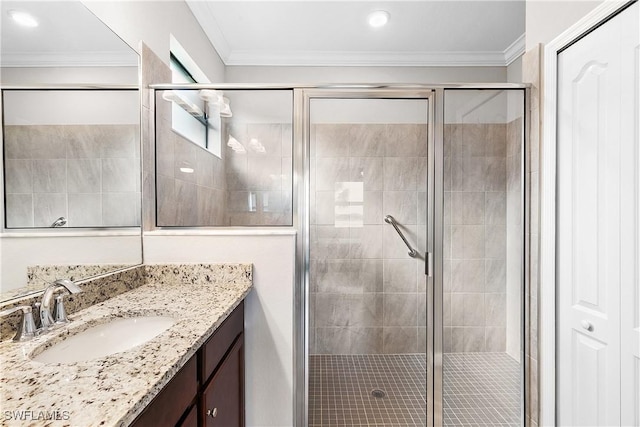 bathroom with vanity, ornamental molding, and a shower with shower door