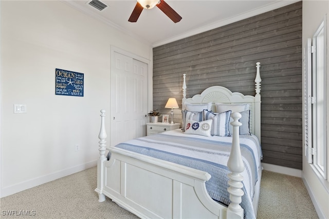 bedroom with light carpet, baseboards, visible vents, ornamental molding, and a closet