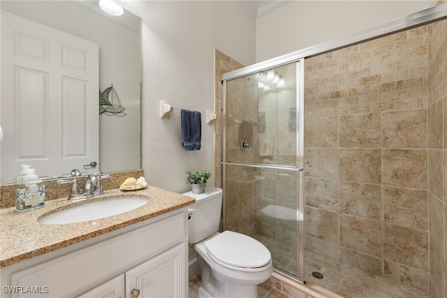 bathroom with toilet, a stall shower, and vanity