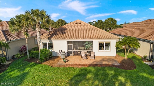 rear view of house featuring a yard and a patio