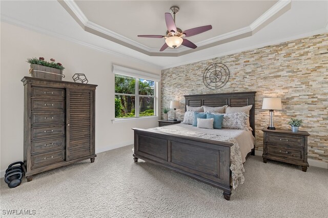 carpeted bedroom featuring a tray ceiling, ceiling fan, and ornamental molding