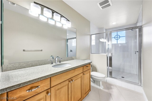 bathroom with vanity, tile patterned floors, toilet, and an enclosed shower