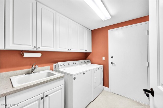 washroom with separate washer and dryer, cabinets, and sink