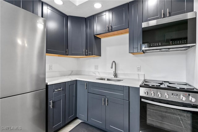 kitchen with light stone counters, sink, and stainless steel appliances