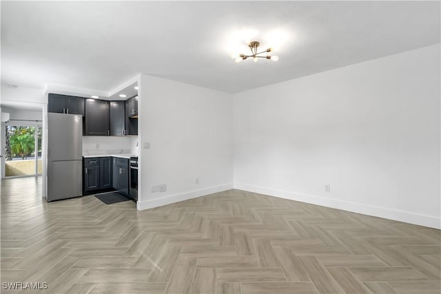 kitchen featuring stove, stainless steel fridge, a chandelier, and light parquet floors