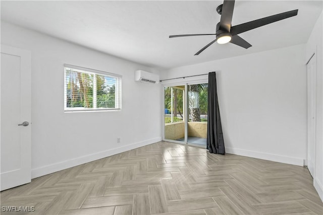 spare room featuring ceiling fan, an AC wall unit, a wealth of natural light, and light parquet floors