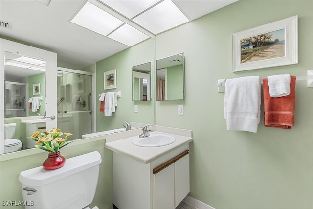 bathroom with visible vents, a stall shower, vanity, and toilet