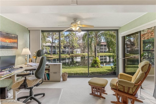 sunroom featuring a water view and ceiling fan