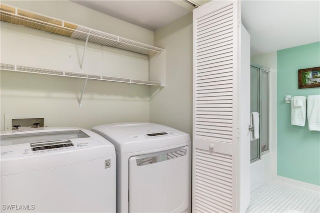 washroom featuring laundry area, light tile patterned floors, and separate washer and dryer