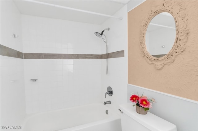 bathroom featuring tiled shower / bath combo and toilet