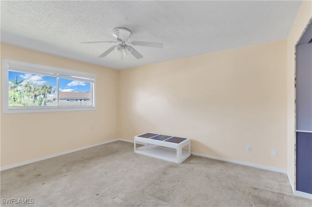 empty room with ceiling fan, a textured ceiling, and light colored carpet