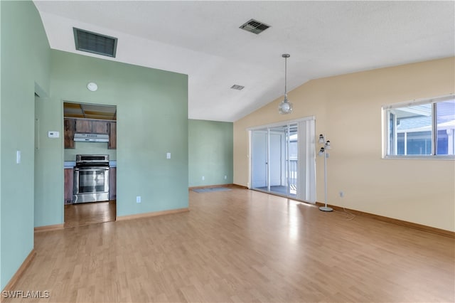 unfurnished living room featuring lofted ceiling, light hardwood / wood-style flooring, and a textured ceiling